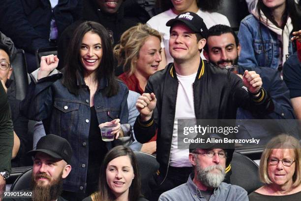 Adam Devine and Chloe Bridges attend a basketball game between the Los Angeles Clippers and the Milwaukee Bucks at Staples Center on March 27, 2018...