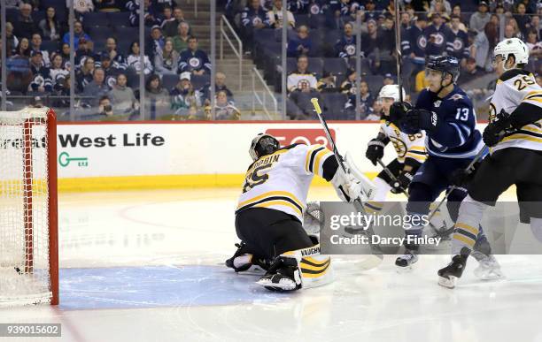 Brandon Tanev of the Winnipeg Jets watches as the puck goes into the net behind goaltender Anton Khudobin of the Boston Bruins for a second period...