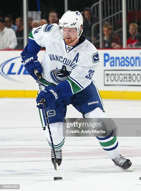 Henrik Sedin of the Vancouver Canucks plays the puck against the New Jersey Devils during their game at the Prudential Center on December 2, 2009 in...