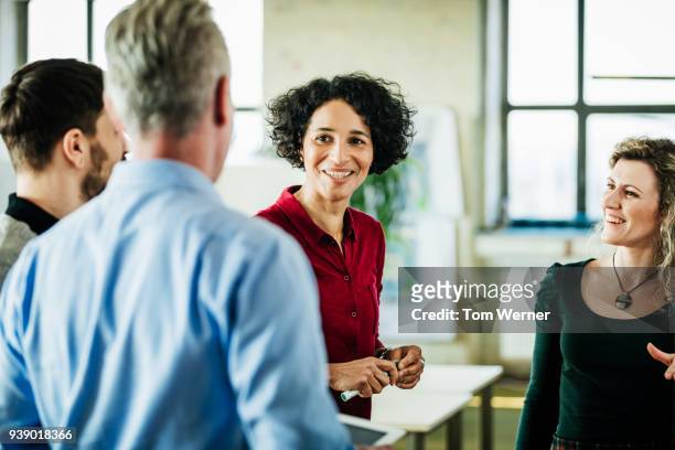 business colleagues having meeting together at office - smiling person white shirt stockfoto's en -beelden