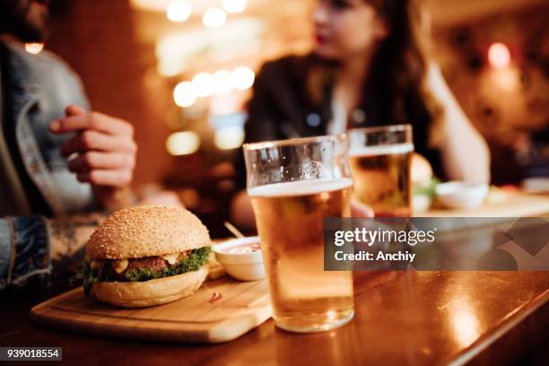 close up of burger and beer on a table - beer and food stock pictures, royalty-free photos & images