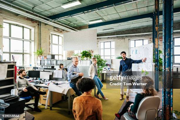 office manager addressing his team during morning meeting - germany team presentation stockfoto's en -beelden