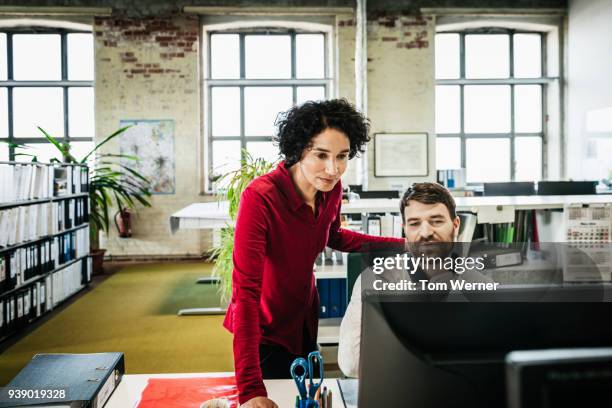 office manager assisting employee with problem - frau aktenordner stock-fotos und bilder