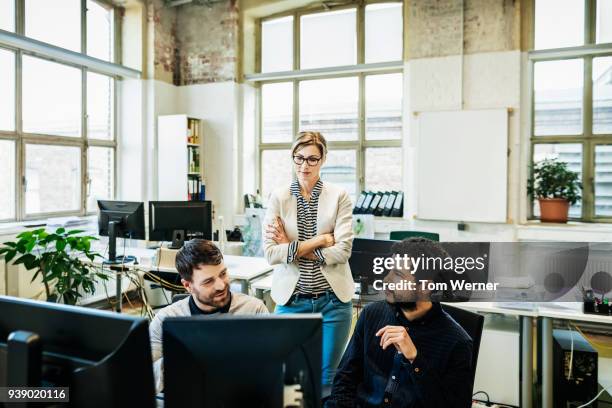 Business Manager Talking To Her Colleagues Working On Computers