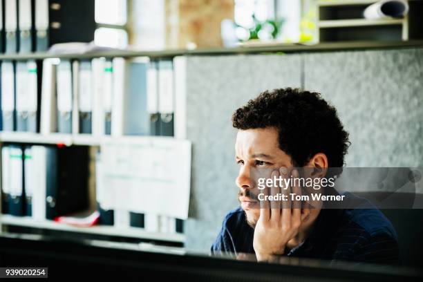 office worker concentrating on technical problem - un seul homme d'âge moyen photos et images de collection
