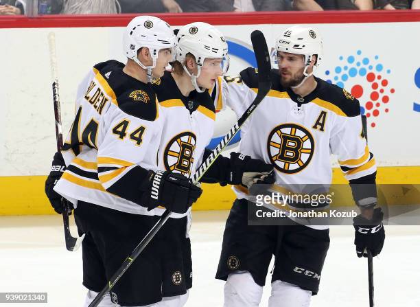 Nick Holden, Danton Heinen and David Krejci of the Boston Bruins celebrate a third period goal against the Winnipeg Jets at the Bell MTS Place on...