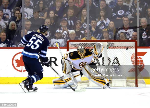 Mark Scheifele of the Winnipeg Jets shoots the puck into the net past goaltender Anton Khudobin of the Boston Bruins for a shootout goal at the Bell...