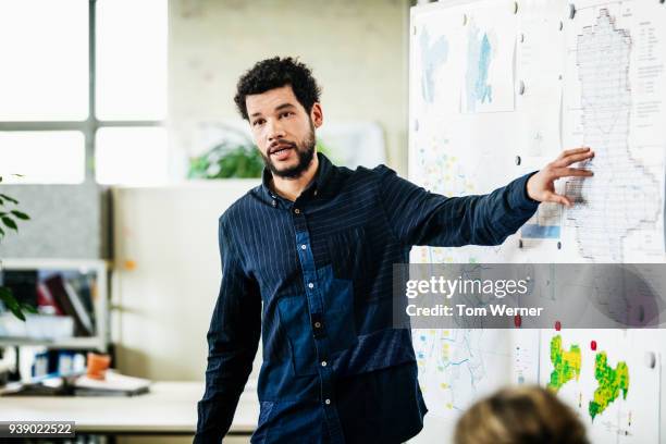 business partner giving presentation at office - black man pointing finger stock pictures, royalty-free photos & images