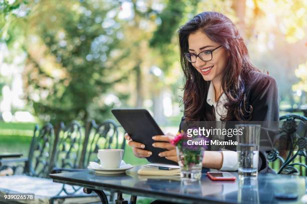 mooie vrouw browsen op haar tablet - 2017 common good forum stockfoto's en -beelden