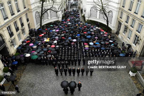 Officials of the French gendarmerie nationale, police officers and French Interior Minister Gerard Collomb hold a minute of silence for...