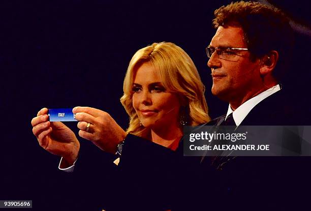 Secretary general Jerome Valcke , flanked by South African actress Charlize Theron holds up Italy during the World Cup 2010 draw at the Cape Town...