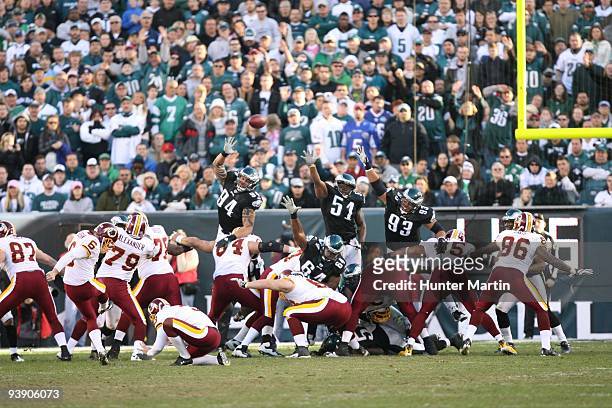 Defensive end Jason Babin, linebacker Joe Mays, and defensive tackle Trevor Laws of the Philadelphia Eagles attempt to block a field goal during a...