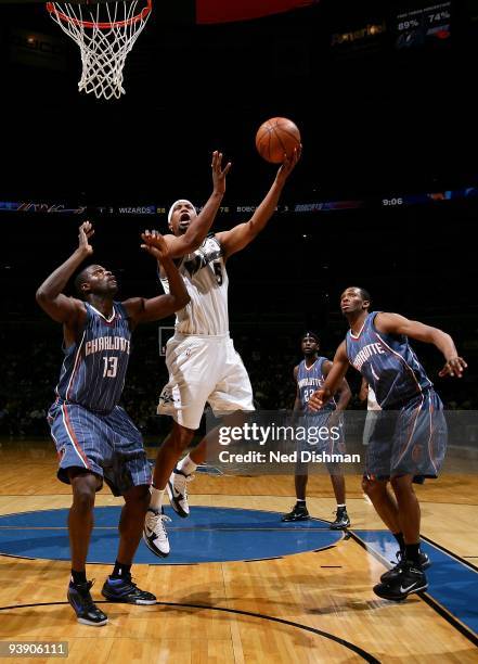 Dominic McGuire of the Washington Wizards goes to the basket against Nazr Mohammed and Stephen Graham of the Charlotte Bobcats during the game on...