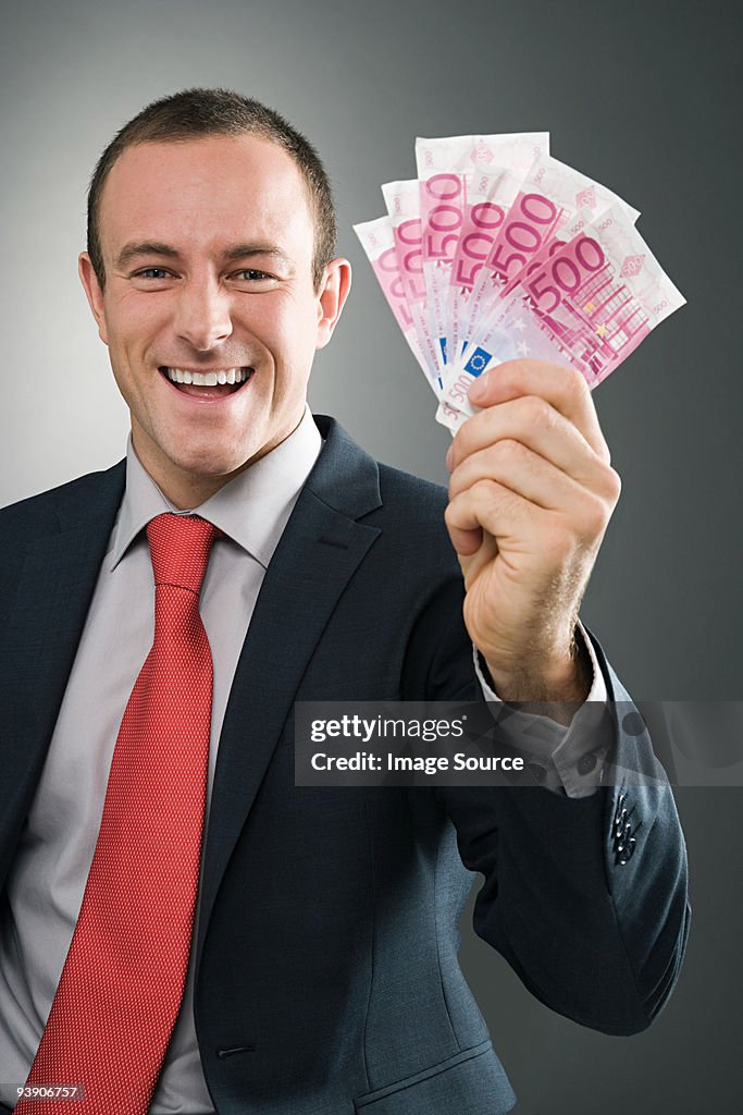 Smiling businessman with bank notes