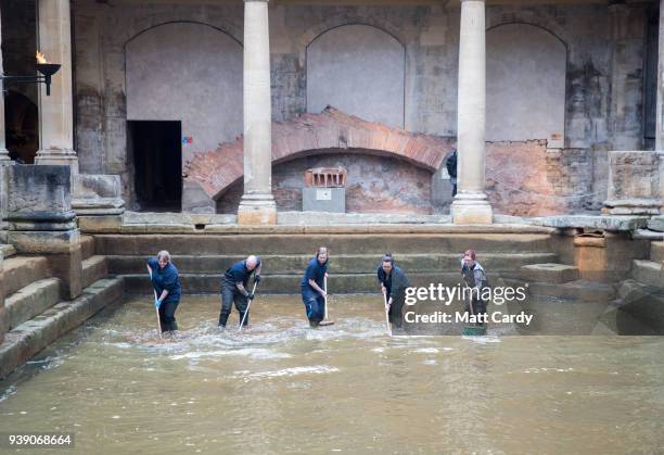 Bath and North East Somerset Council employees brush algae and sludge from the original Roman lead lined floor of the Great Bath as it is drained of...