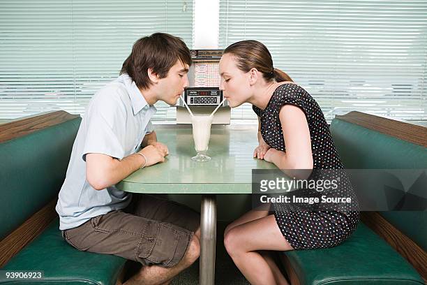 young couple sharing a milkshake - drinking straw 個照片及圖片檔