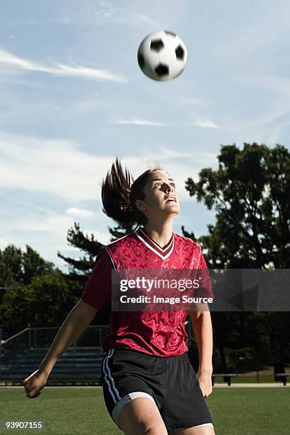 footballer heading the ball - heading the ball stockfoto's en -beelden