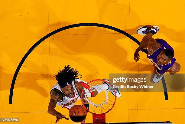 Mikki Moore of the Golden State Warriors puts a shot up over Ron Artest of the Los Angeles Lakers during the game on November 28, 2009 at Oracle...