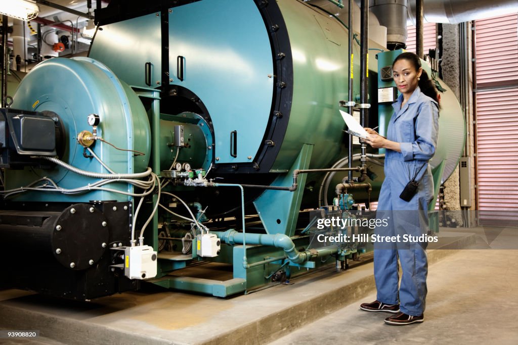 African technician standing next to machinery