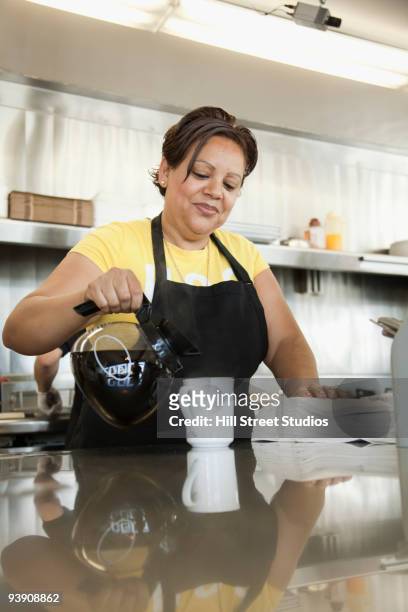 hispanic waitress pouring coffee in diner - coffee pot stock pictures, royalty-free photos & images