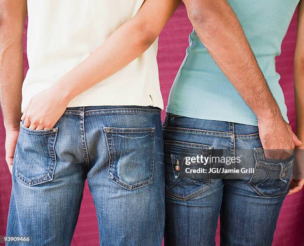 couple with hands in each other's rear jeans pockets - hands in pockets foto e immagini stock