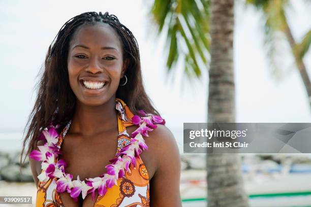 african woman wearing lei on beach - lei day hawaii stock-fotos und bilder