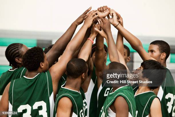 basketball team with arms raised in huddle - basketball sport team stock pictures, royalty-free photos & images