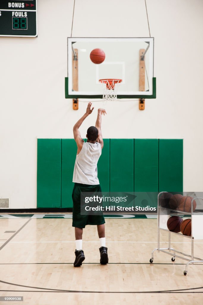 African basketball player practicing free throws in gym