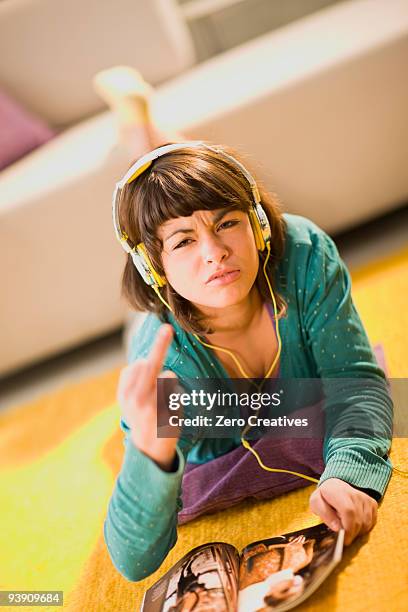 angry girl with headphones and magazine - stubborn stock-fotos und bilder