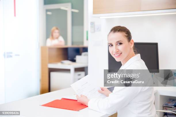 portret van de arts van de vrouw bij haar kliniek - assistente stockfoto's en -beelden