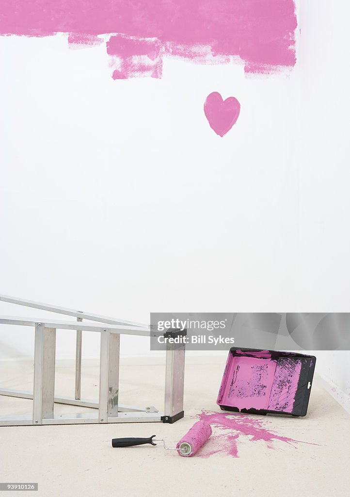 Painted heart on wall and spilt paint