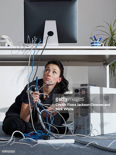an office girl tries to fix her computer - technofobie stockfoto's en -beelden