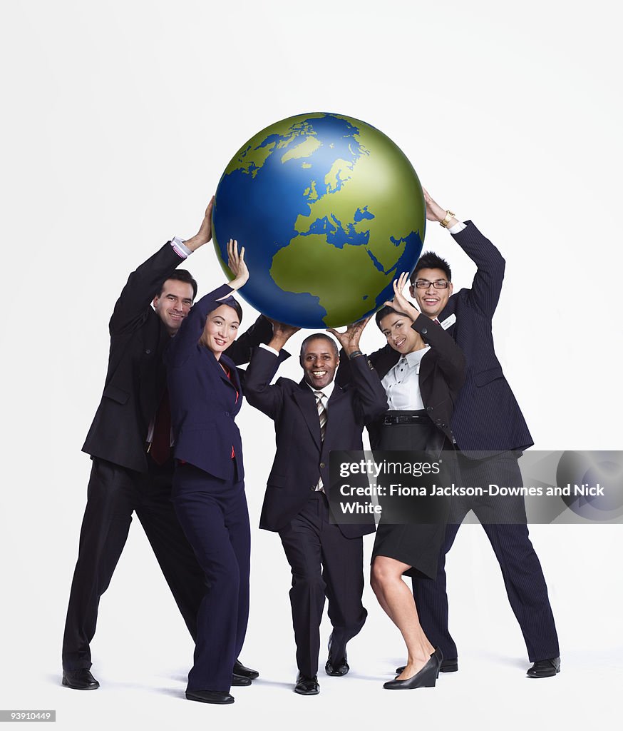 A business group holding up a big globe