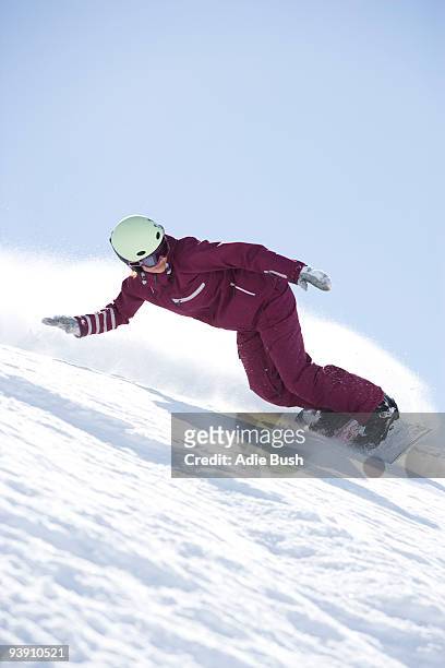 girl in jumpsuit boarding down hill. - sweden snowboarding stock pictures, royalty-free photos & images