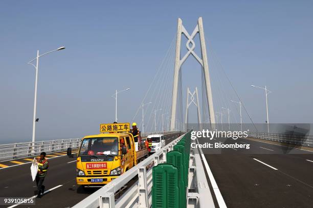 Workers labor on a section of the Hong Kong-Zhuhai-Macau Bridge during a media tour of the bridge offshore in Zhuhai, China, on Wednesday, March 28,...