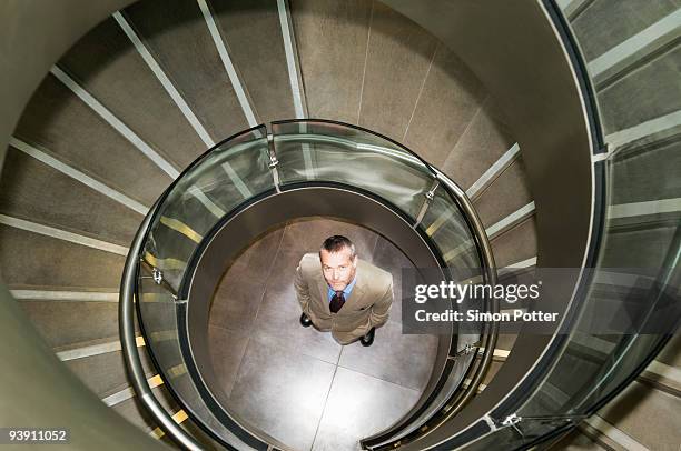 business man at bottom of spiral stairs - marylebone photos et images de collection