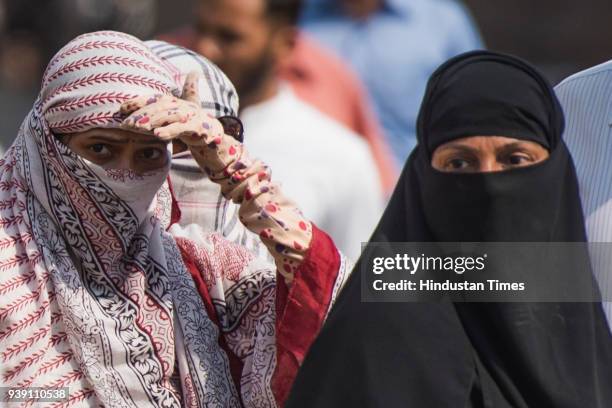 Girls cover their face with a scarf to protect the face from the heat at Mahalaxmi, on March 26, 2018 in Mumbai, India. After a week of pleasant...