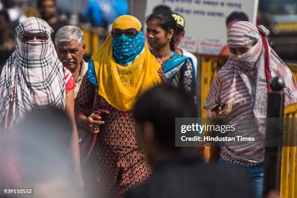 Girls cover their face with a scarf to protect the face from the heat at Mahalaxmi, on March 26, 2018 in Mumbai, India. After a week of pleasant...