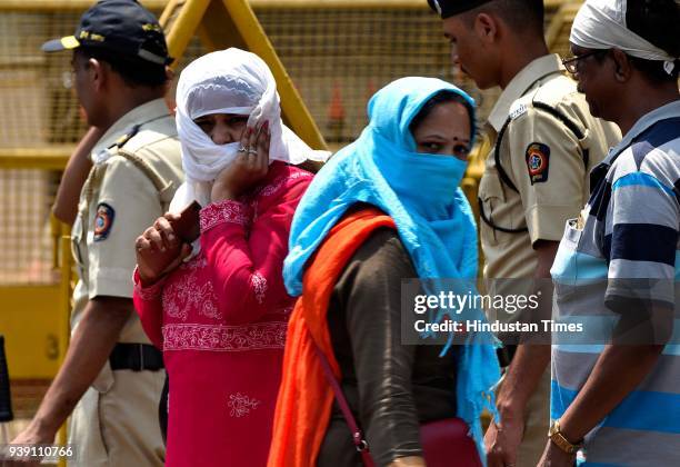 Pedestrian cover themselves from rising temperature at CSMT, on March 26, 2018 in Mumbai, India. After a week of pleasant weather, the scorching...