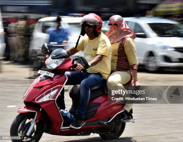 Pedestrian cover themselves from rising temperature at CSMT, on March 26, 2018 in Mumbai, India. After a week of pleasant weather, the scorching...