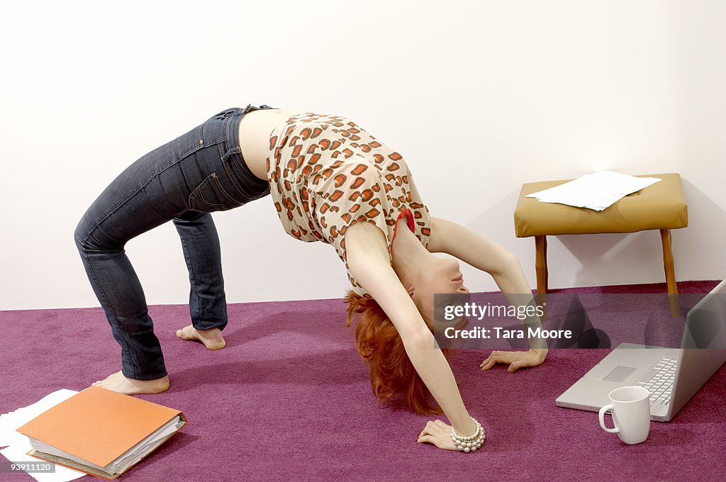Woman doing yoga looking at computer