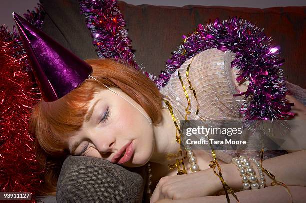 woman with party hat asleep on sofa - acostado de lado fotografías e imágenes de stock