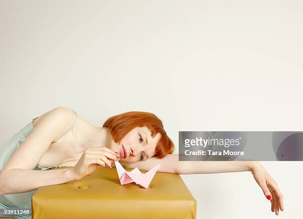 woman looking at origami swan - ligga på mage bildbanksfoton och bilder