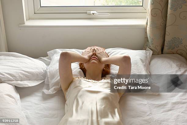 woman on bed with hands over eyes - woman worried bildbanksfoton och bilder