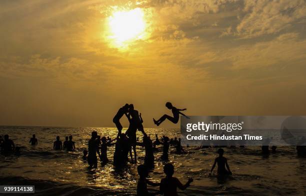 Tourist form human pyramid at Juhu Beach during sunset, on March 25, 2018 in Mumbai, India. After a week of pleasant weather, the scorching summer...