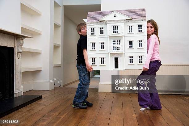 two children carrying a dollhouse - doll house imagens e fotografias de stock