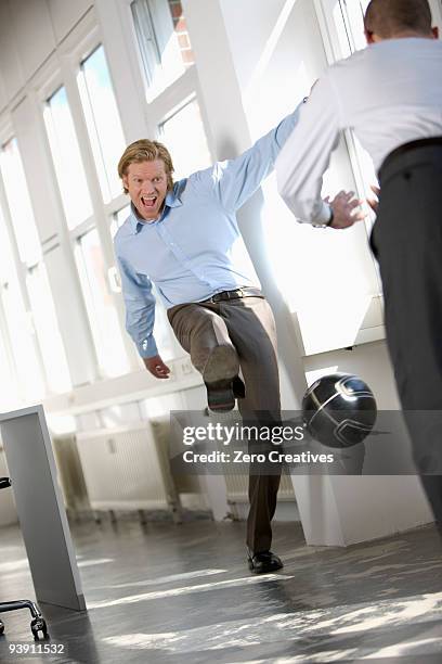 men are playing soccer in an office - verteidiger fußball stock-fotos und bilder