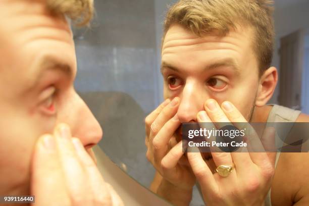 man looking into eyes in mirror - person with red eyes stock pictures, royalty-free photos & images