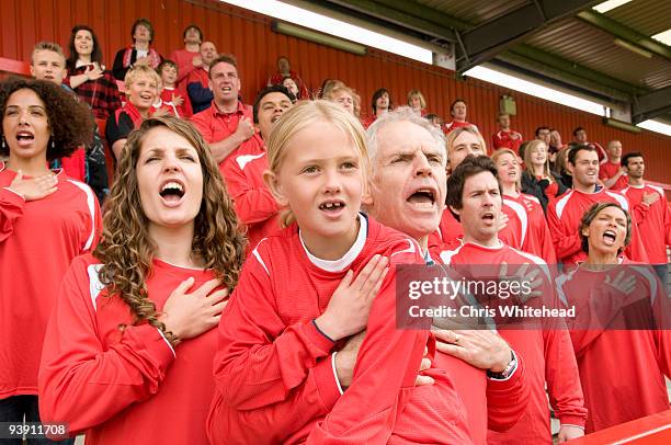 fans singing anthem at football match - girl who stands stock pictures, royalty-free photos & images