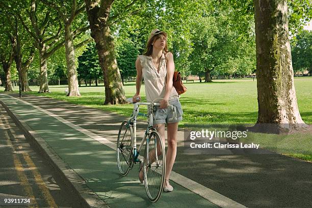 woman walking holding bike - hackney weekend stock pictures, royalty-free photos & images